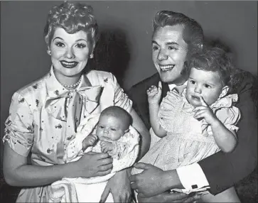  ?? Hulton Archive / Getty Images ?? LUCILLE BALL and her husband, Desi Arnaz, hold their two children, Desi Jr. and Lucie, in 1953.