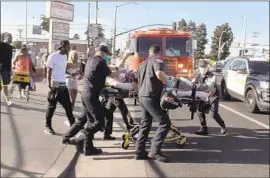  ?? OnScene.TV ?? A MAN is taken to an ambulance after being shot on South Vermont Avenue near Imperial Highway on Thursday. A woman was shot about half a mile away.