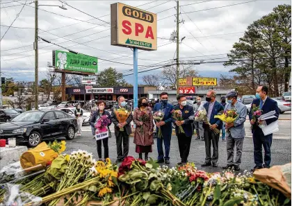  ?? ALYSSA POINTER/ ALYSSA. POINTER@ AJC. COM ?? Members of the Atlanta Korean- American Committee Against Asian Hate Crimes hold a vigil Friday outside Gold Spa in Atlanta for those slain Tuesday. The group consists of Korean American community members, business and religious leaders.