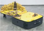  ?? PACE GALLERY, NEW YORK ?? Chinese artist Yin Xiuzhen uses clothing — typically found in suitcases — to create landscapes based on real cities. In this work, the Chinese city of Dunhuang is re-created in shades of yellow. Remarkably, the work remains intact when the suitcase is...