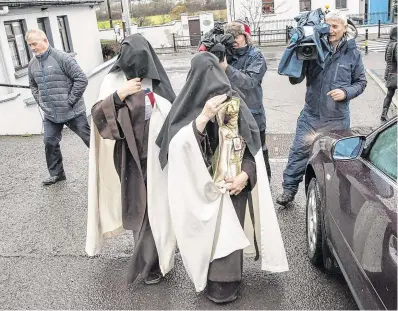  ?? PHOTO: DARAGH McSWEENY ?? Hiding: The Carmelite nuns hurry away from the court with the Child of Prague statue.