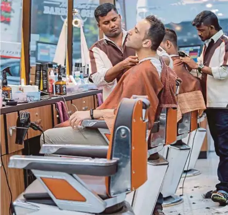  ??  ?? Barbers tending to customers at a barber shop in Brickfield­s, Kuala Lumpur. PIC BY AIZUDDIN SAAD