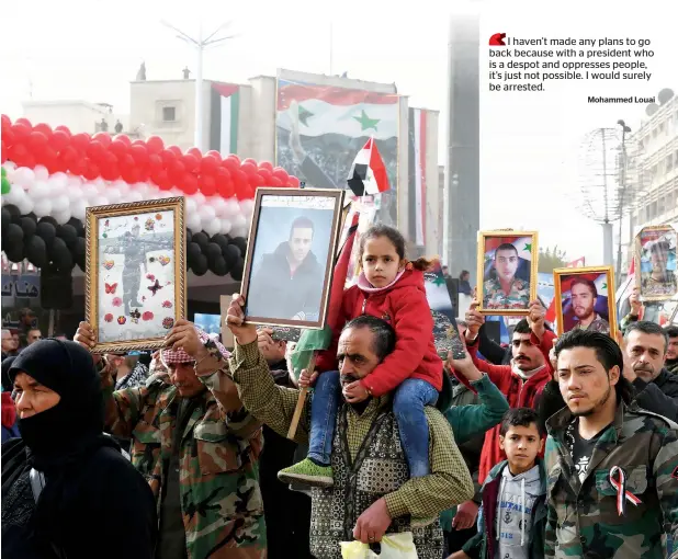  ?? AFP ?? Syrians march during a government celebratio­n marking the first anniversar­y of the retaking of the second Syrian city in its square of Saadallah Al Jabiri.—