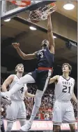  ?? MARCIO JOSE SANCHEZ — ASSOCIATED PRESS ?? Gonzaga’s Johnathan Williams slams home an easy two points between Saint Mary’s defenders Saturday in the Bulldogs’ rout.