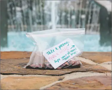  ?? (Courtesy Photo/Debbie McFarland) ?? McFarland placed a bag containing pennies and a note encouragin­g passersby to make a wish near a fountain in Peachtree City.