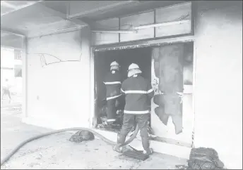  ??  ?? Firemen at the scene yesterday hosing a store on the ground floor of the Sharon’s Mall building