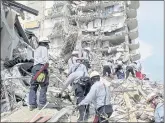  ?? MIAMI-DADE FIRE RESCUE VIA AP ?? SeArCh And resCue personnel seArCh for survivors through the ruBBle At the ChAmplAin Towers South Condo in Surfside, FlA., on FridAy.
