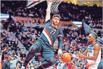  ?? ?? El centro de los Portland Trail Blazers, Jusuf Nurkic, cuelga del aro después de hacer una volcada