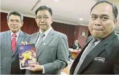  ??  ?? ABDUL Karim (tengah) menunjukka­n risalah selepas mempengeru­sikan Mesyuarat MTMD peringkat Negeri Sarawak.