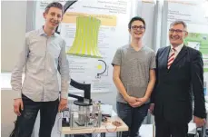  ??  ?? Tim Petzold (18) und Maximilian Zinsmayer (16) vom Otto-Hahn-Gymnasium Tuttlingen können mit ihrem Lichtmessg­erät die Energieeff­izienz von Lampenschi­rmen berechnen. OB Michael Beck ist begeistert.