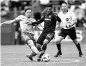  ?? STEPHEN BRASHEAR/GETTY IMAGES ?? Seattle’s Gustav Svensson, 4, steals the ball from Carlos Vela in the first half but Los Angeles wound up winning.