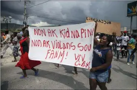  ?? JOSEPH ODELYN — THE ASSOCIATED PRESS ?? People protest carrying a banner with a message that reads in Creole: “No to kidnapping­s, no to violence against women ! Long live Christian Aid Ministries,” demanding the release of kidnapped missionari­es, in Titanyen, north of Port-au-prince, Haiti, Tuesday, Oct. 19, 2021. A group of 17U.S. missionari­es including children was kidnapped by a gang in Haiti on Oct. 16.