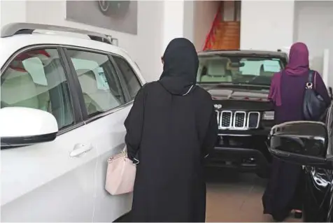  ?? AFP ?? Women at a car dealership in Jeddah on Saturday. Saudi Arabia has ended the world’s only ban on female motorists, a historic reform marred by what rights groups call an expanding crackdown on activists.