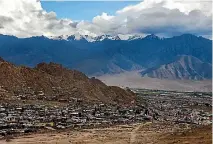  ??  ?? Buildings sit in the Leh Valley as the Himalayas stand in the background.