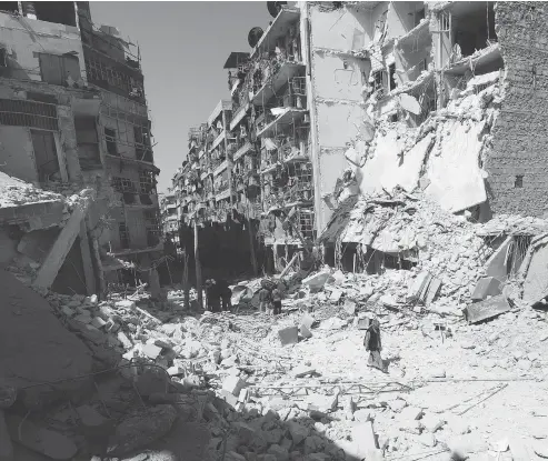  ?? ZEIN AL-RIFAI / AFP / GETTY IMAGES ?? A man walks through the rubble of the northern Syrian city of Aleppo following reported air strikes by government forces on March 27, 2015.