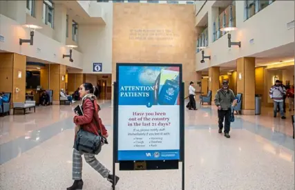  ?? Andrew Rush/Post-Gazette ?? A sign about traveling greets incoming patients Tuesday at the Veterans Affairs Pittsburgh Healthcare System’s University Drive campus in Oakland. The Pittsburgh VA said Tuesday that everyone entering its facilities will be screened for COVID-19.