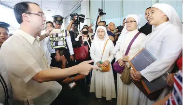  ??  ?? TOUCHING BASE – Foreign Affairs Secretary Alan Peter Cayetano (left) talks to some nuns waiting in line to renew their passports during his inspection of the Department of Foreign Affairs (DFA) Consular Affairs Office at the Aseana Business Park on...