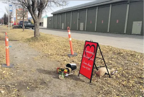  ?? LAUREN KRUGEL /THE CANADIAN PRESS ?? A memorial sign and flowers sit outside Fernie Memorial Arena, where three men died following an ammonia leak while doing maintenanc­e work on icemaking equipment on Tuesday.
