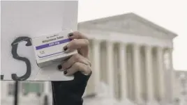 ?? AMANDA ANDRADE-RHOADES/AP ?? An abortion-rights activist holds a box of mifepristo­ne pills outside the Supreme Court building on Tuesday.