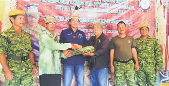  ??  ?? Philip (third right) presents the Rela uniforms to Jacob who is the longhouse Rela unit head, witnessed by Dennis (third left).