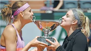  ??  ?? SO SWEET: US Bethanie Mattek-Sands, right, and Czech Republic’s Lucie Safarova kiss the trophy after winning against Australia’s Casey Dellacqua and Kazakhstan’s Yaroslava Shvedova during their women’s double final match.