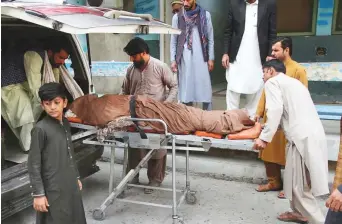  ?? AP ?? People carry the body of a woman who was killed in a stampede in Jalalabad, Afghanista­n, yesterday. She was among the thousands queuing up to apply for a Pakistani visa.