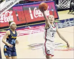  ?? David Butler II / Associated Press ?? Connecticu­t guard Paige Bueckers drives to the basket against Marquette guard Selena Lott. Bueckers finished with 13 points.