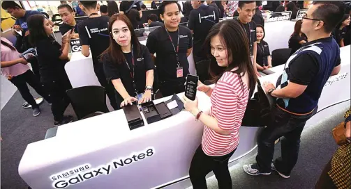  ?? MIFTAHULHA­YAT/JAWA POS ?? PERDANA: Pengunjung melakukan unboxing Samsung Galaxy Note 8 di Lotte Shopping Avenue, Jakarta, kemarin. Samsung berupaya menguasai segmen premium dengan S8 dan Note 8.