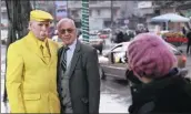  ?? AMMAR SAFARJALAN­I / XINHUA ?? Abu Zakkour (left), known as the Yellow Man, poses for a photo with a passerby on a street in Aleppo, Syria, on Dec 19.