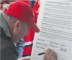  ?? COREY LAROCQUE / POSTMEDIA NETWORK ?? Gordon Stringer signs a petition calling for Ontario to pass Rowan’s Law,
an act governing the management of youth concussion in sports.