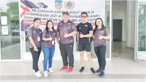  ??  ?? TERBAIK: Atlet angkat berat Sabah yang bertanding di Melaka bersama jurulatih angkat berat pelapis kebangsaan, Nicholas Wong (tengah) yang juga bekas atlet Sabah.