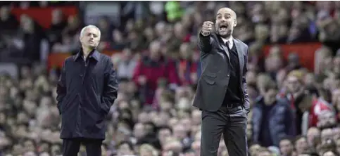  ?? —AFP ?? MANCHESTER: Manchester United’s Portuguese manager Jose Mourinho (L) watches as Manchester City’s Spanish manager Pep Guardiola gestures on the touchline during the EFL (English Football League) Cup fourth round match between Manchester United and...