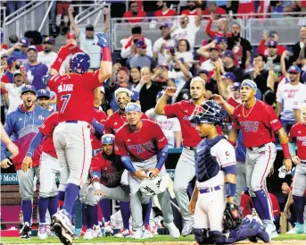  ?? ?? Puerto Rico designated hitter Christian Vazquez celebrates with teammates after hitting a solo home run against the Dominican Republic at the World Baseball Classic at loanDepot park on Wednesday in Miami.