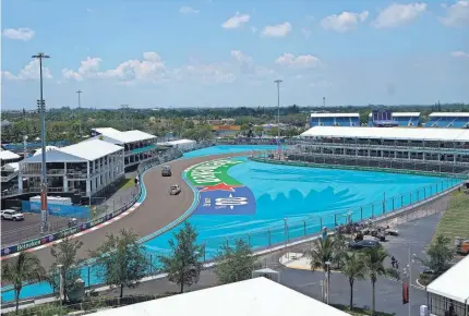  ?? DARRON CUMMINGS/AP ?? Workers make their way around Miami Internatio­nal Autodrome on Thursday in preparatio­n for the F1 Miami Grand Prix race Sunday.