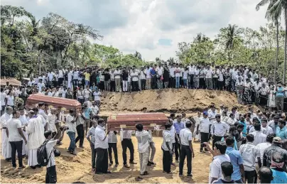  ?? PHOTO: GETTY IMAGES ?? In mourning . . . Coffins are carried to a grave during a mass funeral at St Sebastian’s Church yesterday in Negombo, Sri Lanka.