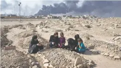  ?? MARKO DROBNJAKOV­IC / THE ASSOCIATED PRESS FILES ?? A family grieves at a graveyard damaged by ISIL in Iraq. For Canada, Afghanista­n was the “good” war that we joined instead of the “bad” war in Iraq, writes Raymond J. de Souza.