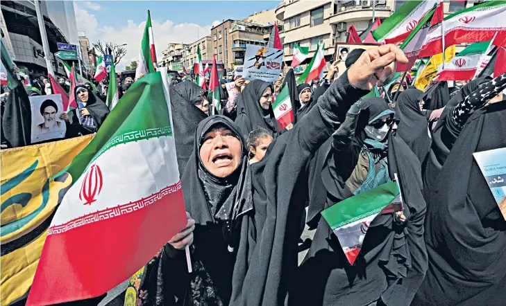  ?? ?? A worshipper chants slogans during an antiIsrael­i gathering after Friday prayers in Tehran. Below, the aftermath of the attack, and the booster of an missile, likely Israeli in origin, that was found in Iraq