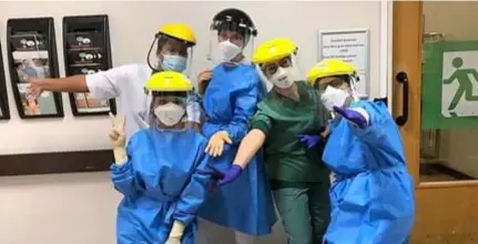  ?? FOTO RR ?? Sieglinde als verpleegku­ndige klaar voor de strijd op de Covid-afdeling van het ZNA-ziekenhuis Stuivenber­g omringd door collega’s Zhima, Anastasia, Ihssan en Imke.