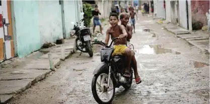  ??  ?? RECIFE: Boys ride a scooter at a slum in Recife, Pernambuco state, Brazil. Brazilian officials still say they believe there’s a sharp increase in cases of microcepha­ly and strongly suspect the Zika virus, which first appeared in the country last year,...