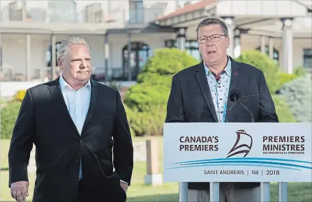  ?? ANDREW VAUGHAN THE CANADIAN PRESS ?? Ontario Premier Doug Ford, left, and Saskatchew­an Premier Scott Moe talk with reporters as the Canadian premiers meet in St. Andrews, N.B.