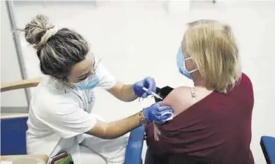  ?? AGENCIAS ?? Una sanitaria en el momento de poner una vacuna de AstraZenec­a a una paciente.