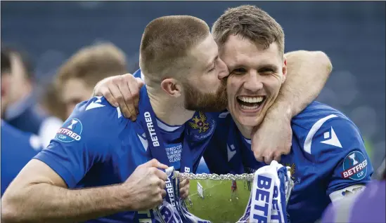  ??  ?? Jason Kerr (right) and Shaun Rooney share an emotional moment, lifting the Betfred Cup at Hampden on Sunday