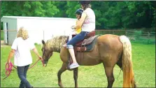  ?? COURTESY PHOTO ?? A Restoratio­n Village volunteer leads a resident and her daughter in equine therapy. “AIM for Advocacy” sporting clays fundraiser Aug. 26 will benefit the nonprofit organizati­on.