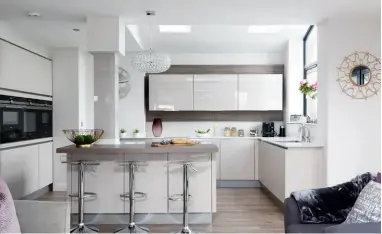  ??  ?? Below: The kitchen island acts as a breakfast bar and social space – it is perfect for relaxed family living The elegant white stove offers a pretty feature in the striking blue living room