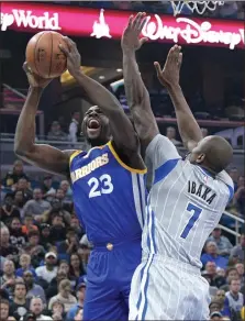  ?? Phelan M. Ebenhack / The Associated Press ?? Golden State’s Draymond Green (left) is fouled by Orlando’s Serge Ibaka while going up for a shot during the first half of Sunday’s game.