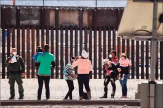  ?? JUSTIN HAMEL / AFP via Getty Images ?? Border Patrol agents apprehend a group of migrants near downtown El Paso, Texas, following the congressio­nal border delegation visit on Monday.