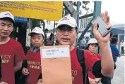  ?? AFP ?? Relatives of Chinese passengers from the missing Malaysia Airlines flight MH370 hold a protest outside the Malaysia Airlines office in Subang on the outskirts of Kuala Lumpur on Feb 12.