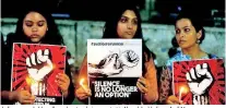  ??  ?? Indian women hold candles and posters during a protest in Ahmedabad, India, on April 16