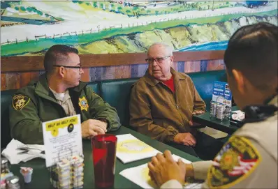  ?? PHOTOS BY WADE VANDERVORT ?? From left, Metro Police Officer Keith Twigger, Ed Keith and Officer Sergio Felix talk during a meet and greet event called Coffee with a Cop. Metro played host to the outreach event Wednesday at the Egg &amp; I restaurant.