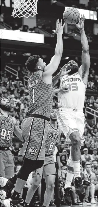  ?? Michael Wyke / Associated Press ?? Rockets guard James Harden, right, shoots against Atlanta’s Evan Turner during Saturday night’s blowout of the Hawks at Toyota Center. Harden finished with his fourth career 60-point game.